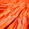 Falda plisada naranja de satén con cintura alta – Núria Aymerich